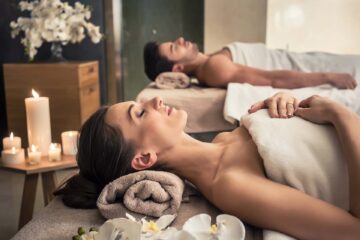 Young woman and man lying on massage beds in luxury spa.